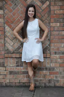 Teen in White Dress Against Brick Wall