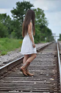 Teen Model in Cowgirl Boots, White Dress on Railroad Tracks