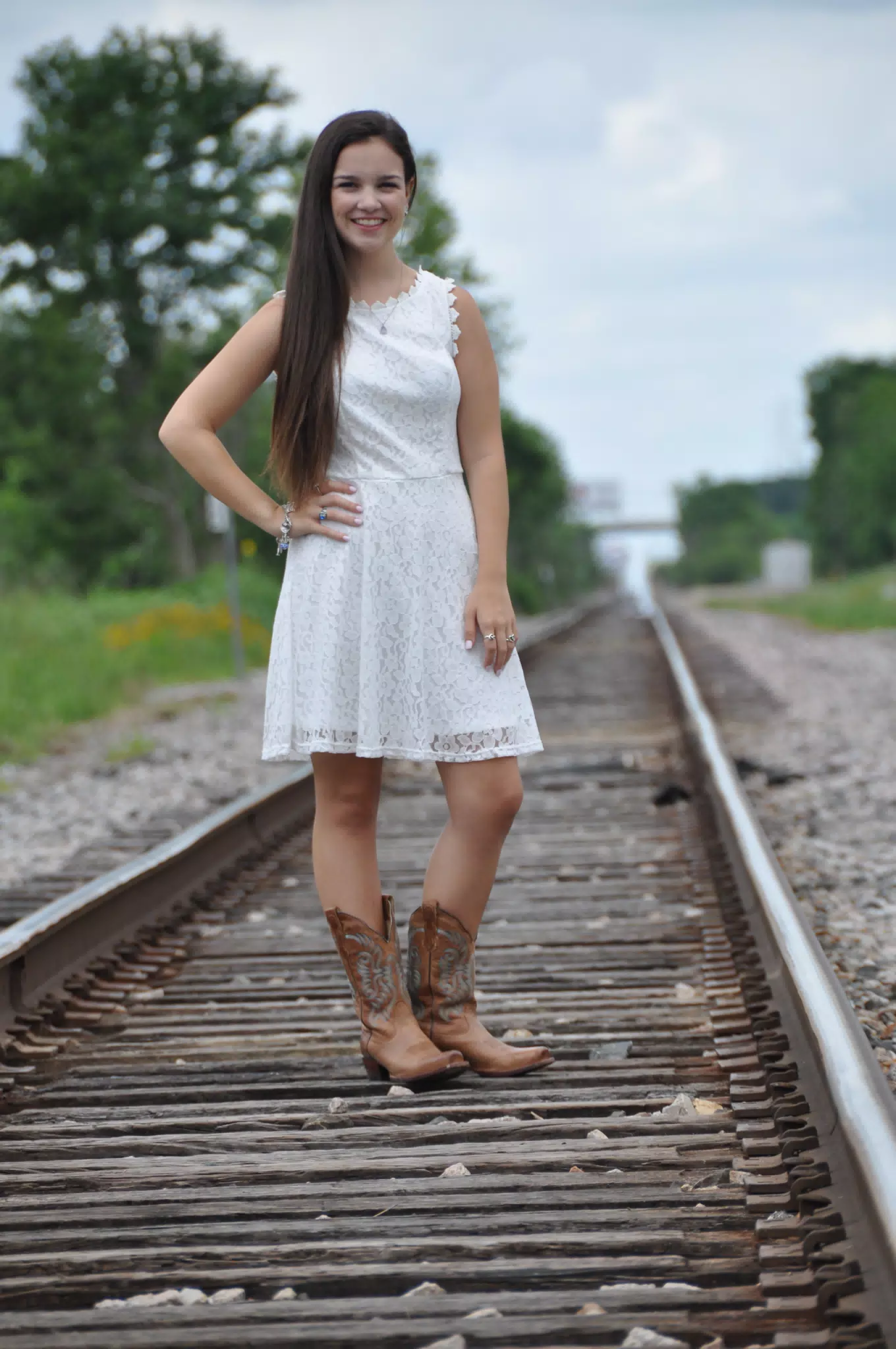 Teen in White Dress and Boots on Railroad Tracks in Texas