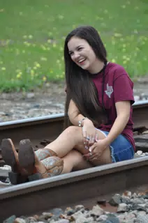Brunette Model Laughing on Railroad Tracks