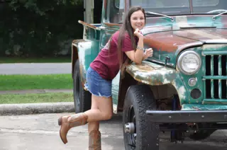 Teen Model in Jean Skirt and Boots Leaning on Jeep
