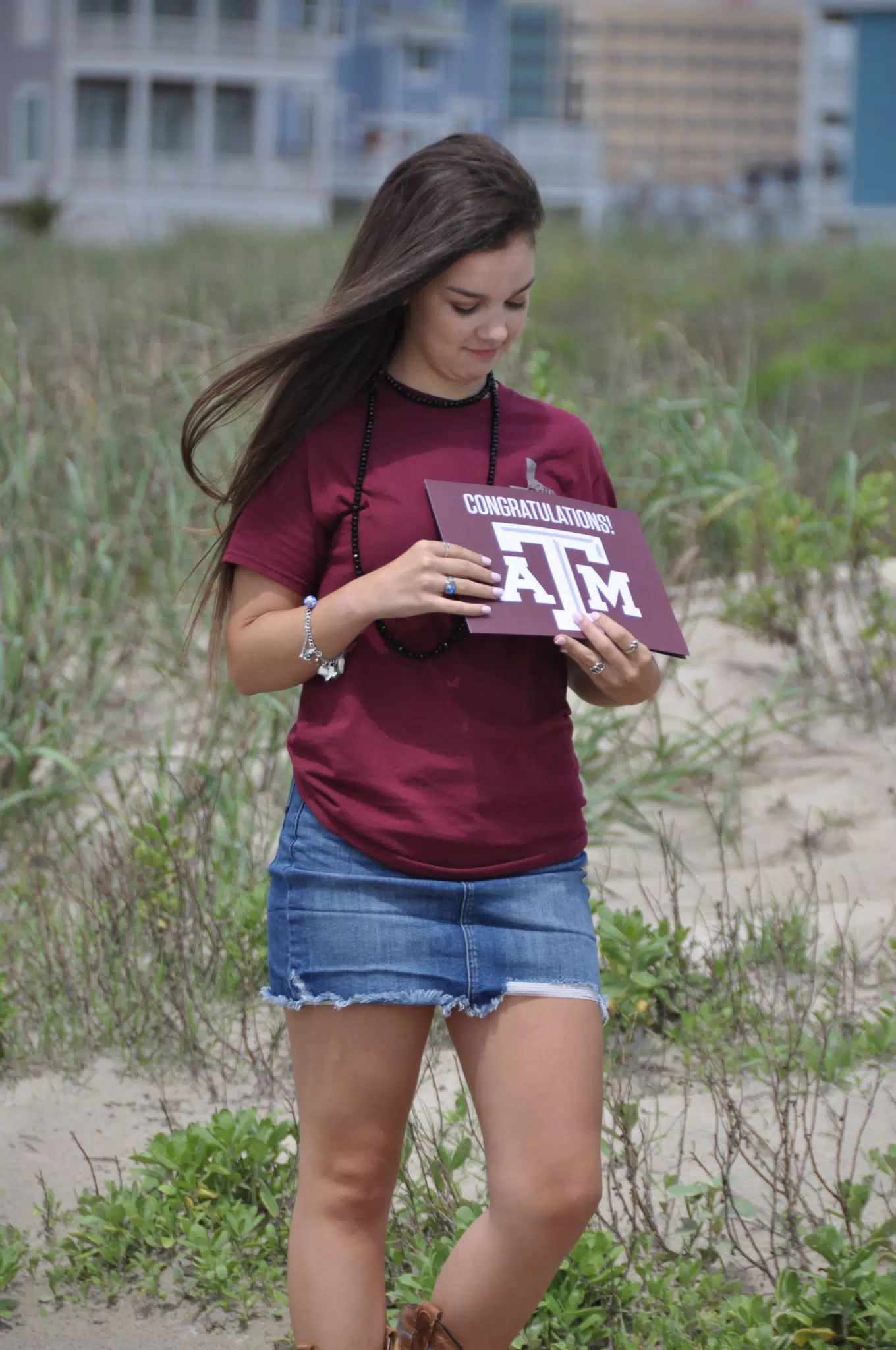 Emily Looking at Her Aggie Sign