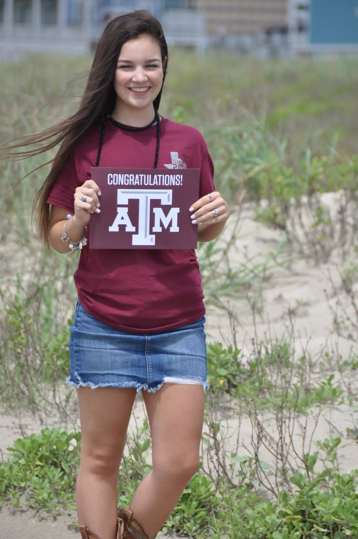 Emily with Aggies Sign on Galveston Beach
