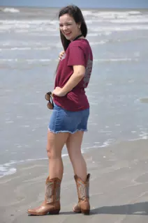 Brunette Teen Model in Boots and Miniskirt on Beach Laughing Over Her Shoulder