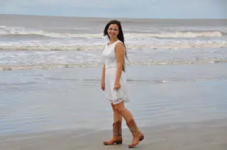 Girl in White Dress and Boots on Beach