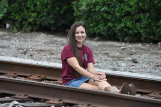 Brunette Teen Emily Sitting on Railroad Tracks in Texas in Denim Skirt and Cowboy Boots