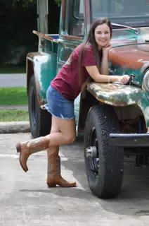 Model in Jean Skirt and Cowgirl Boots with Old Jeep