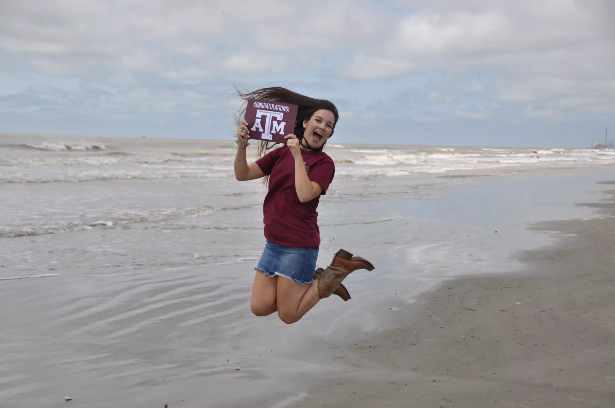 Emily Jumping with Texas A&M Sign on Galveston Beach
