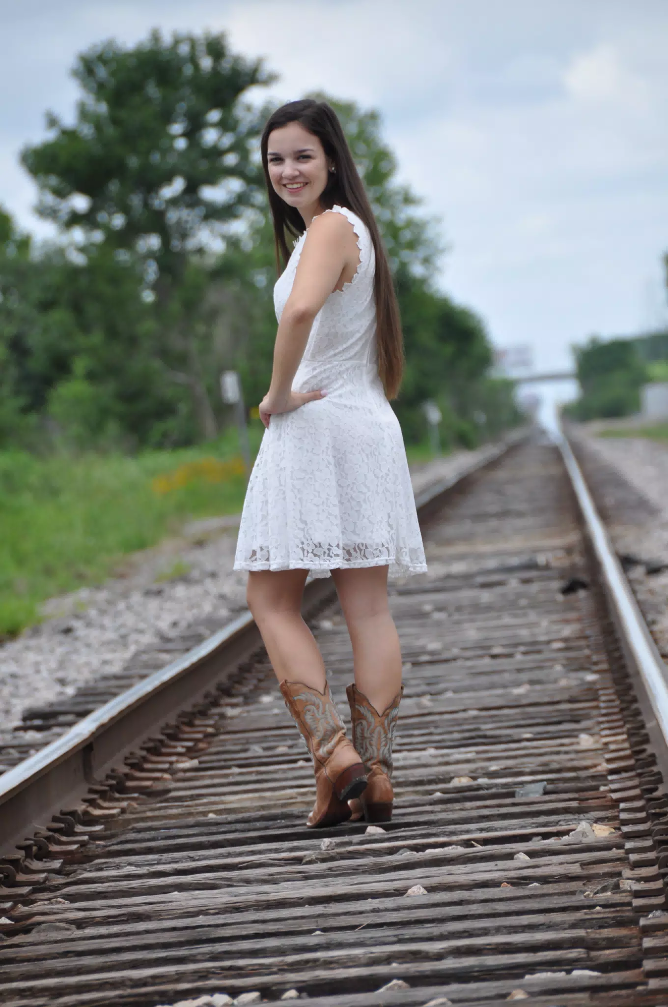 Teen Model in White Dress on Railroad Tracks