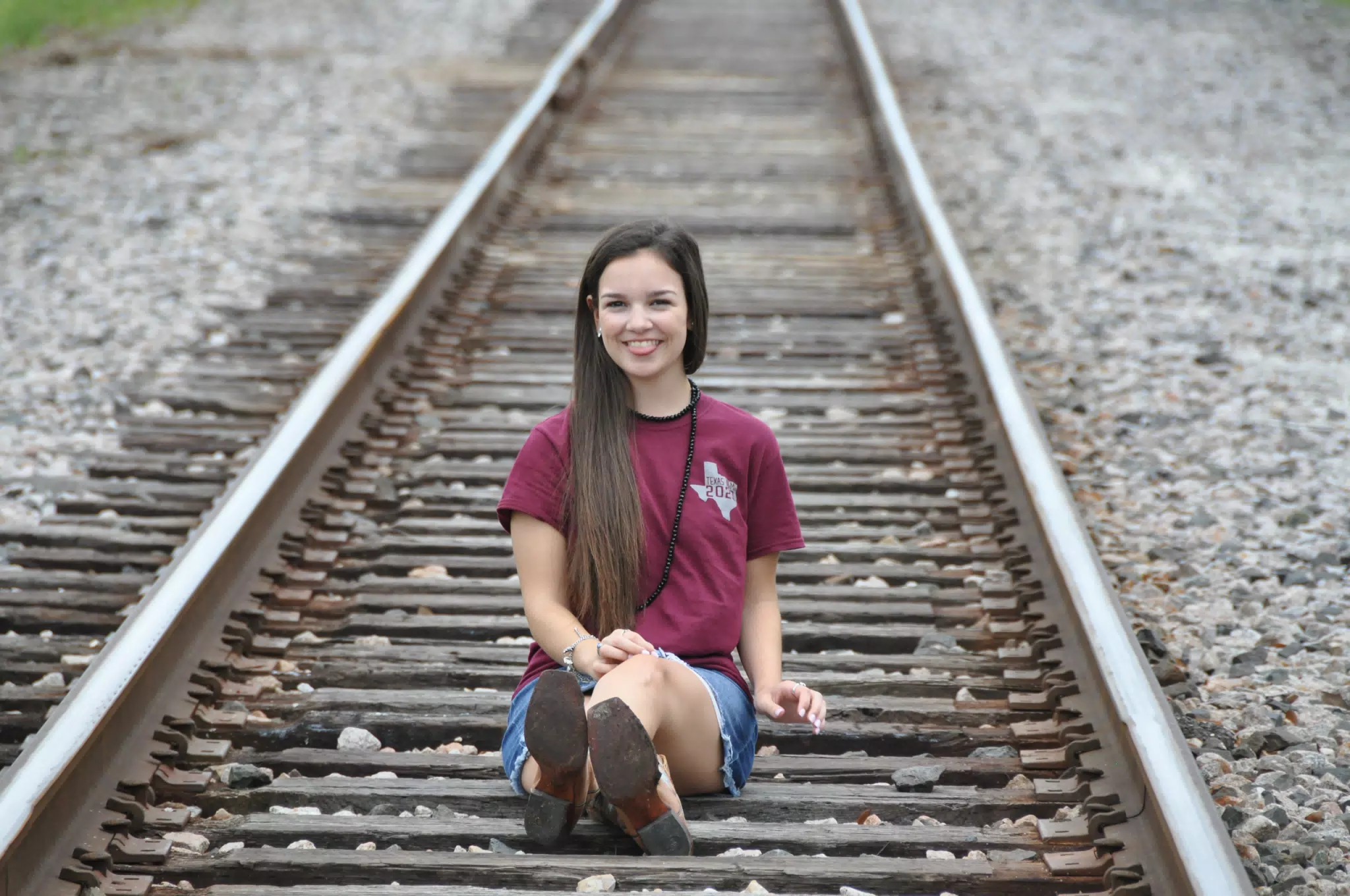 Model Sticking Out Tongue on Railroad Tracks