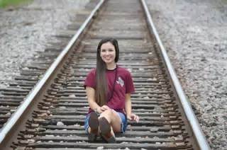 Model Sticking Out Tongue on Railroad Tracks