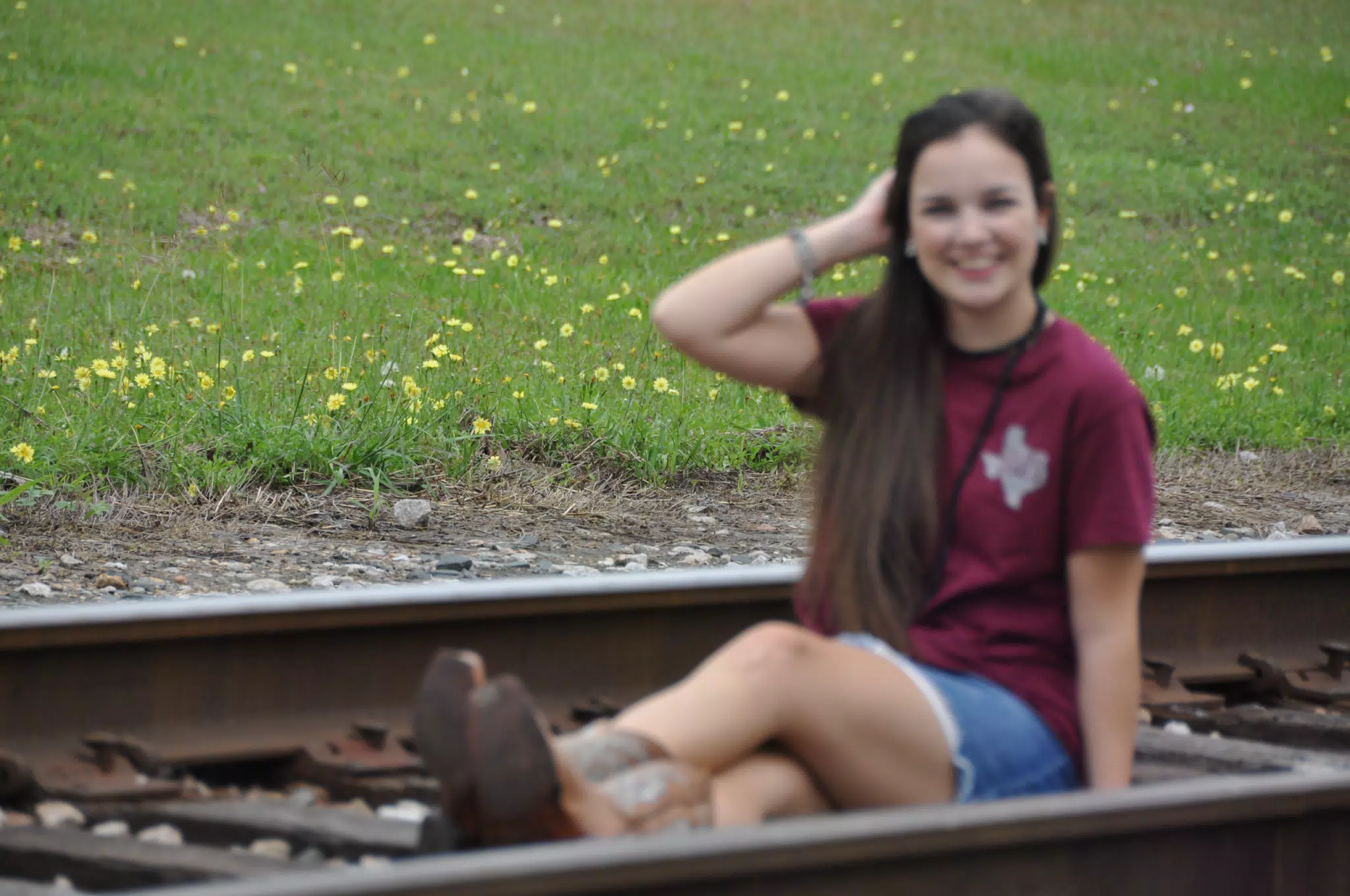 Yellow Texas Flowers Behind Model on Railroad Tracks