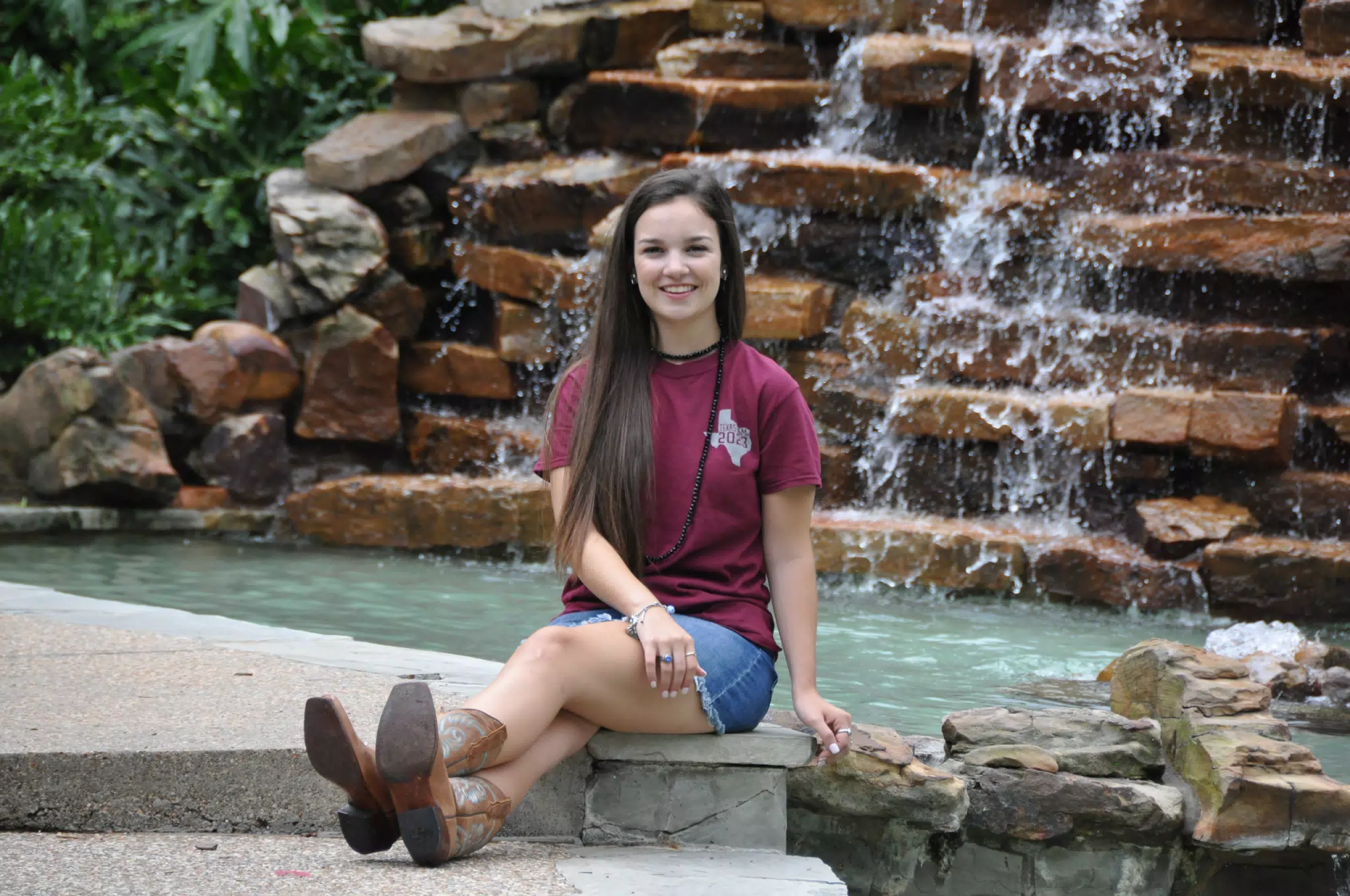 Brunette Model in Cowboy Boots by Waterfall in Garden