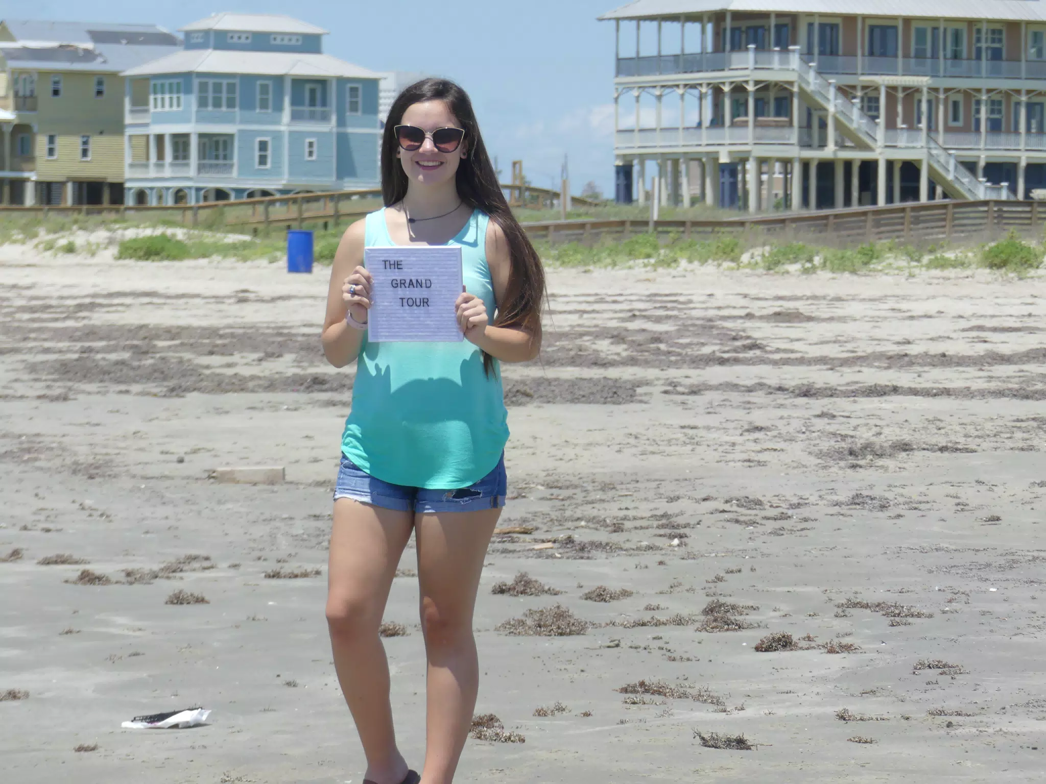 Emily with Grand Tour Sign on Beach