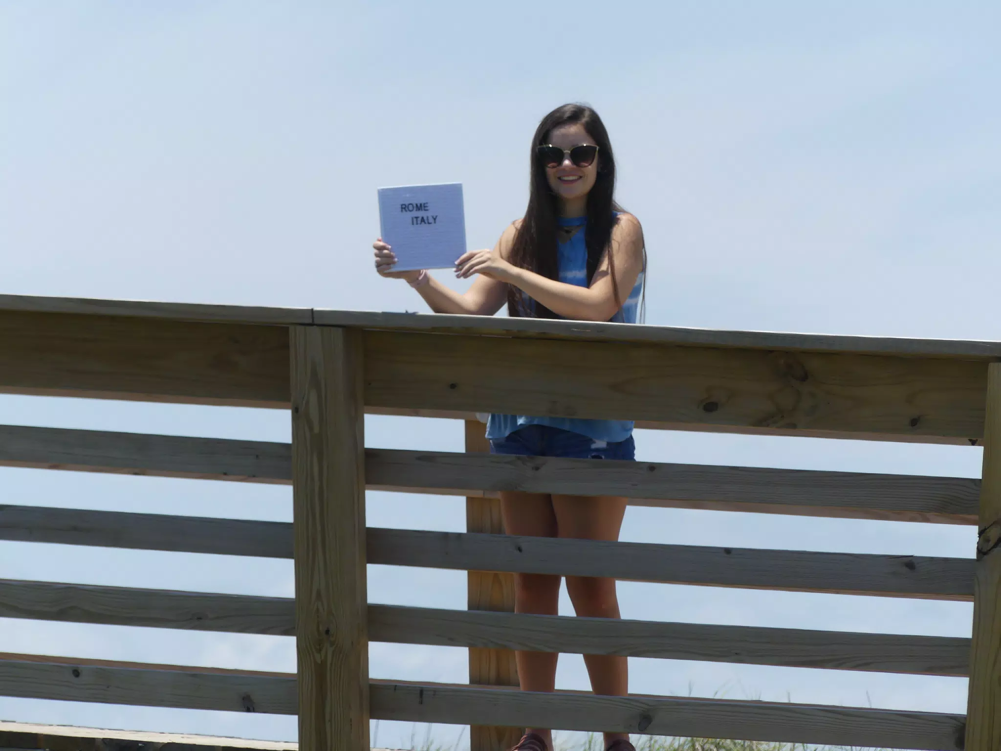 Emily Holding Sign on Galveston Beach Boardwalk