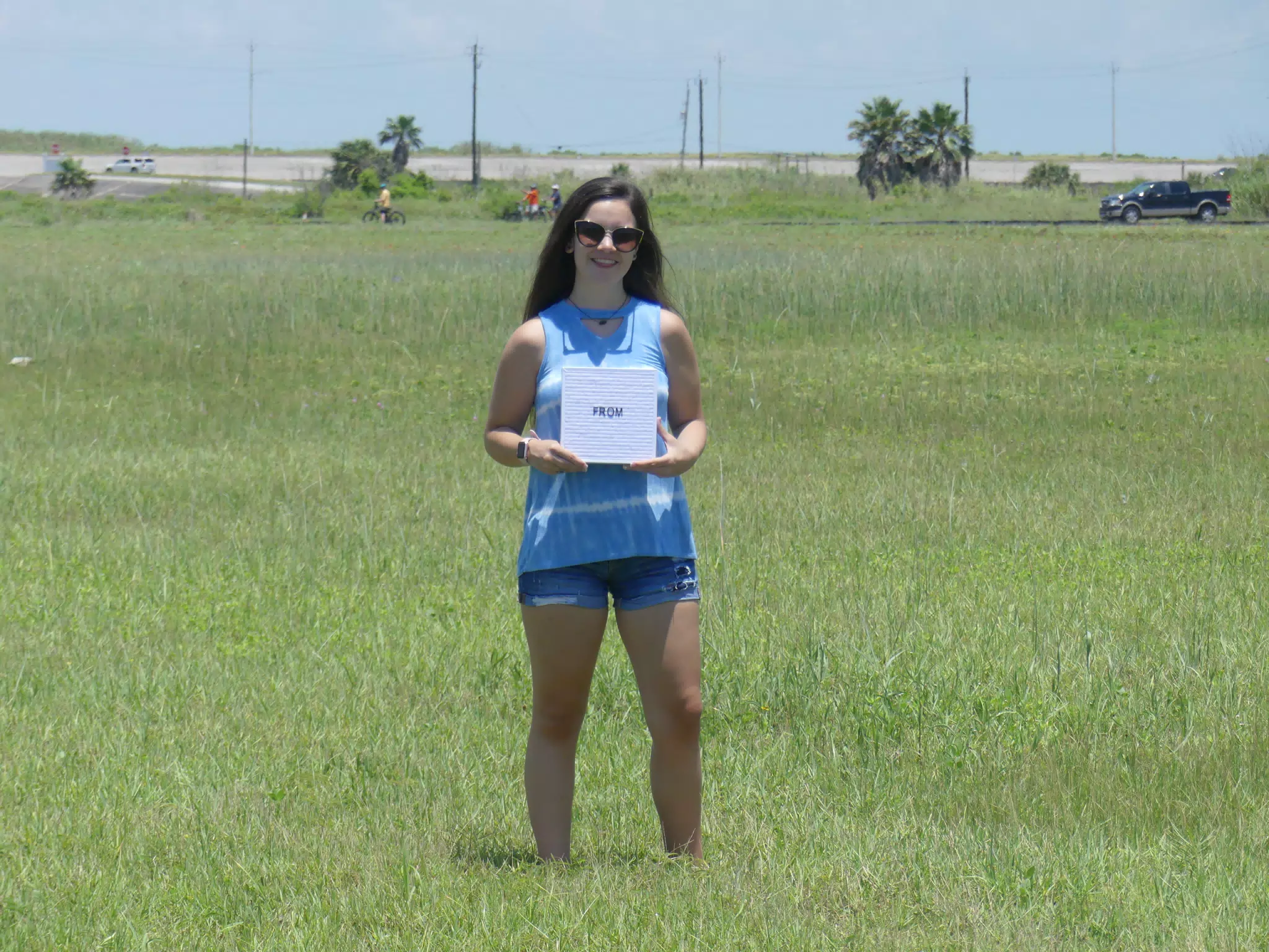 Brunette Teen Model in Field with Sign on Galveston Island in Jean Shorts, Denim