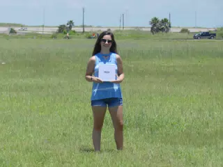 Brunette Teen Model in Field with Sign on Galveston Island in Jean Shorts, Denim