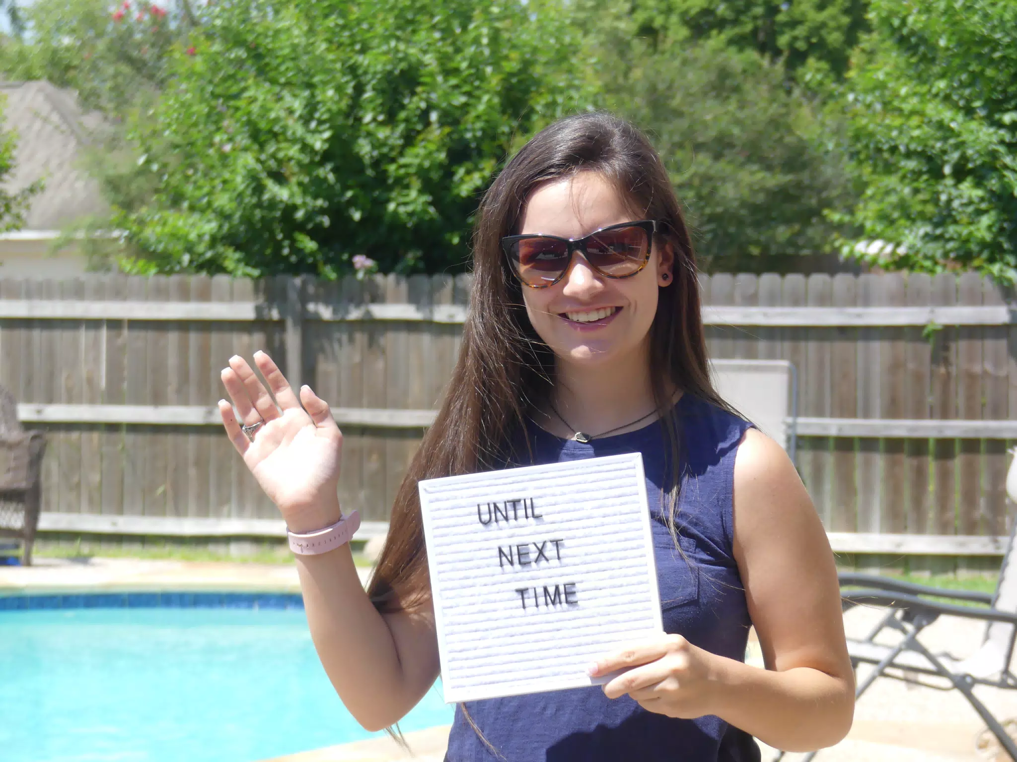 Teen Girl Holding Until Next Time Sign by Swimming Pool