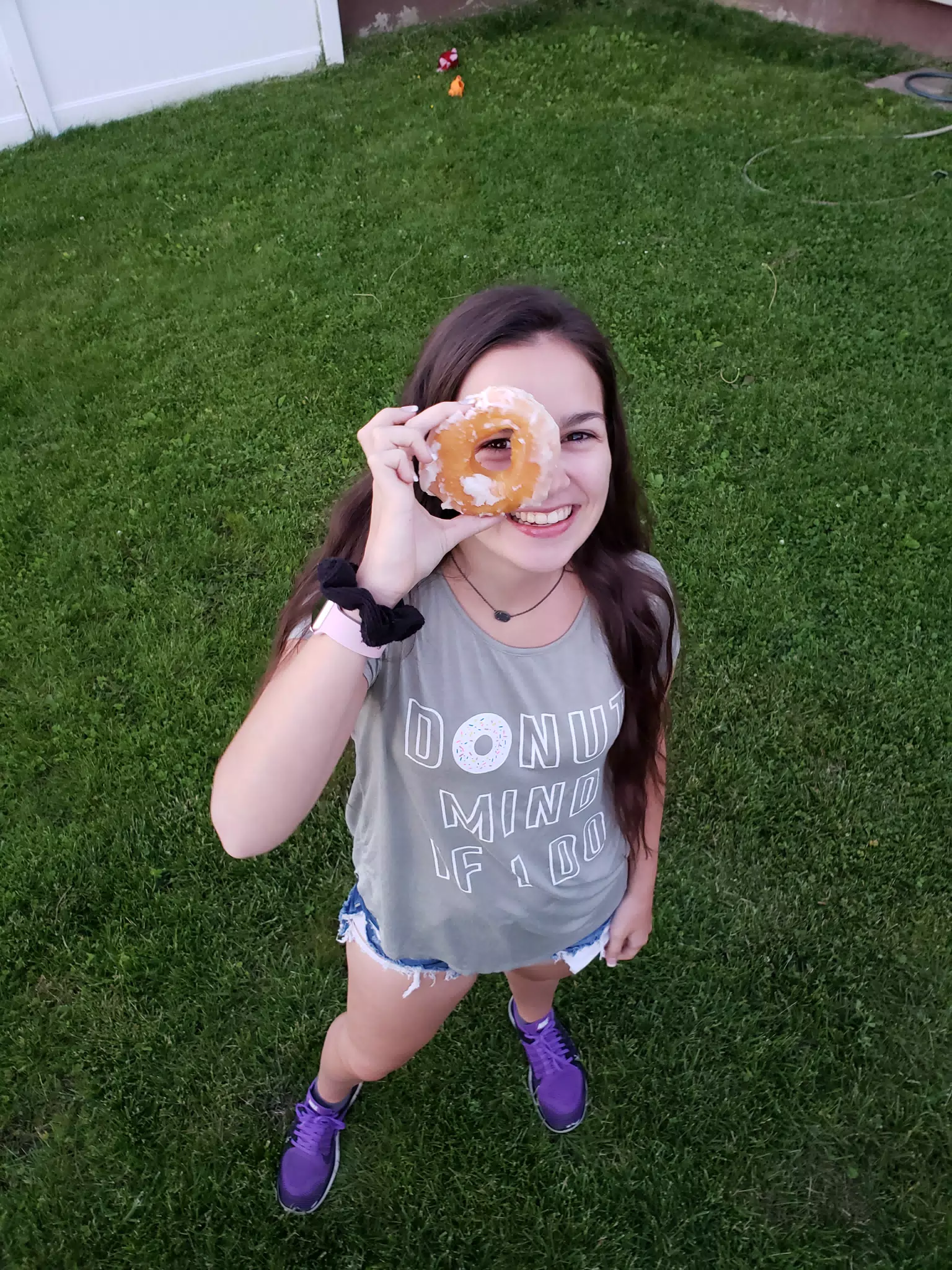 Girl Standing Looking Through Donut
