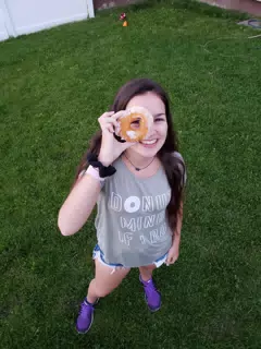 Girl Standing Looking Through Donut