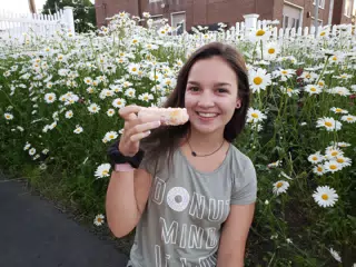 Emily Eating Donut in Field of Flowers
