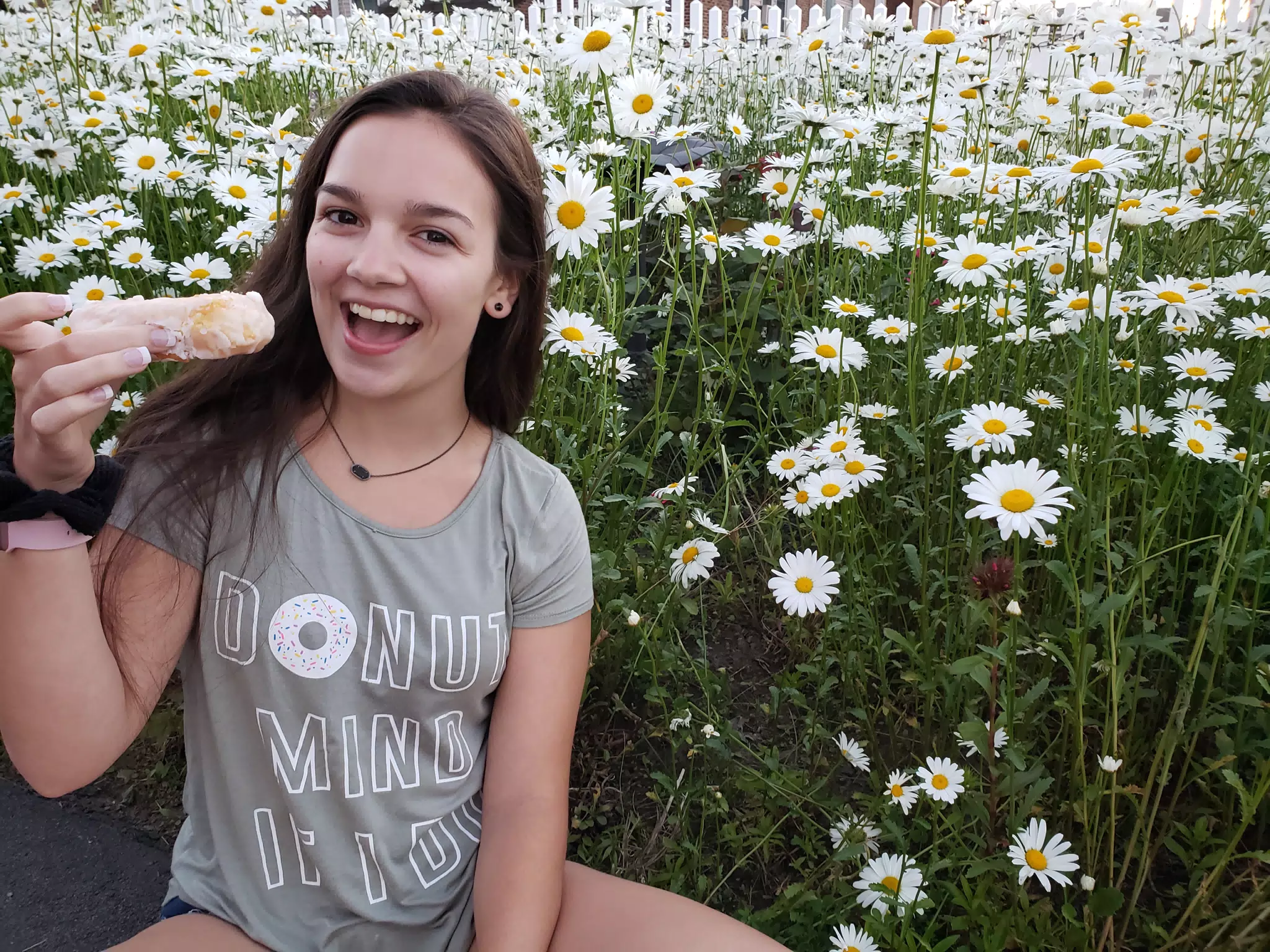 Girl Eating Donut in Field of Flowers