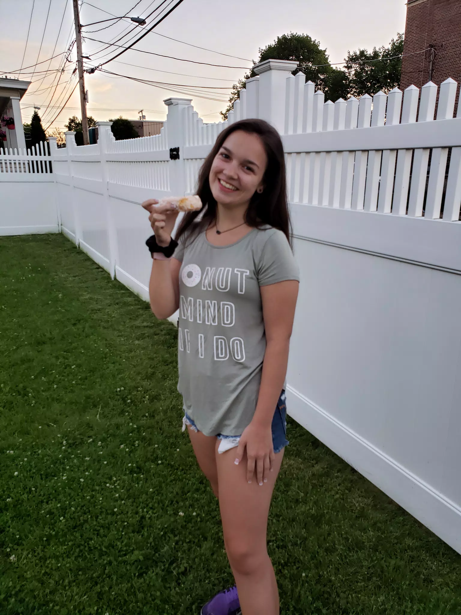 Emily with Doughnut by Fence