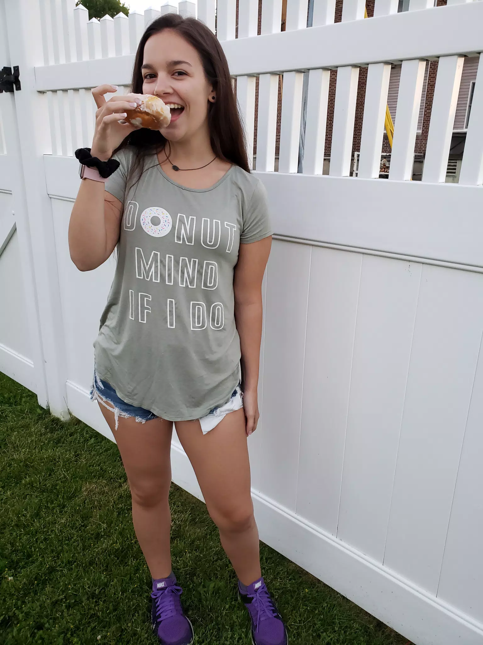 Emily Eating Doughnut by Fence