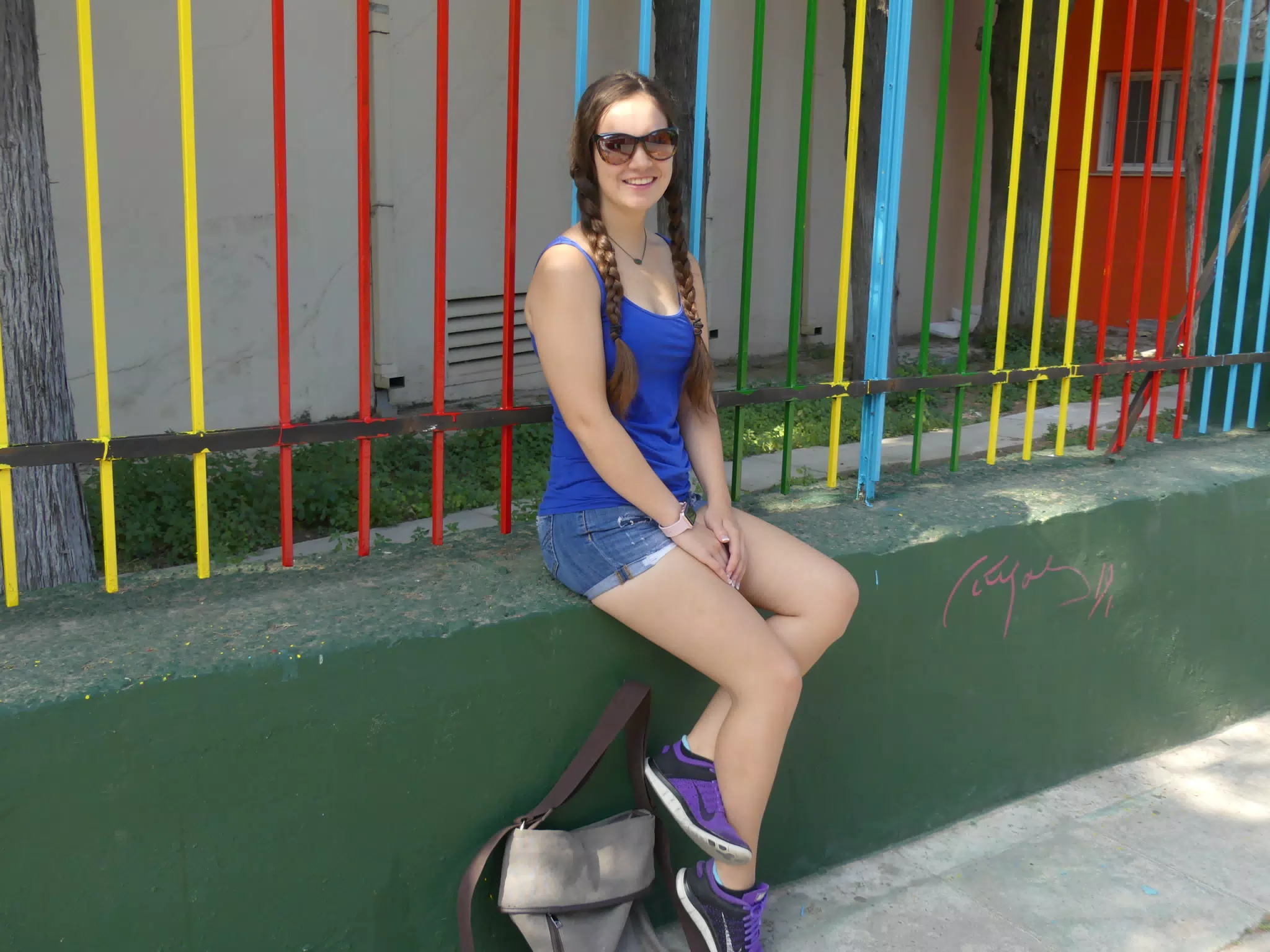Girl by Fence on Athens Sidewalk