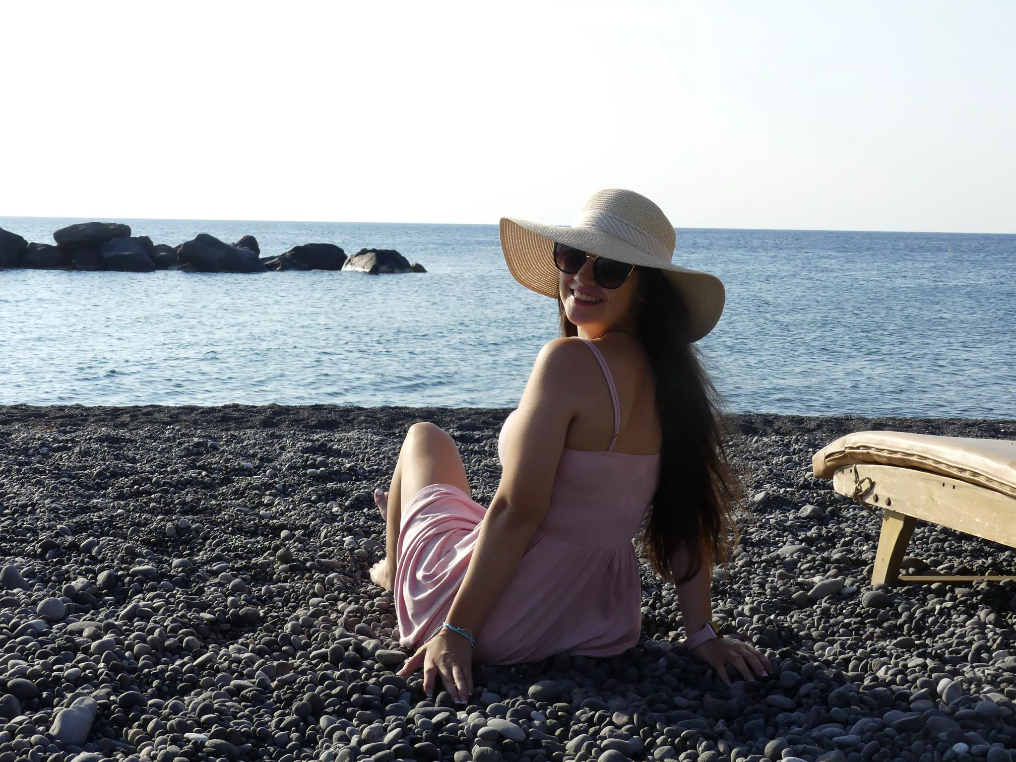 Girl Looking Back on Kamari Beach on Aegean Sea on Santorini