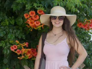 Girl with Hat and Red Flowers on Santorini