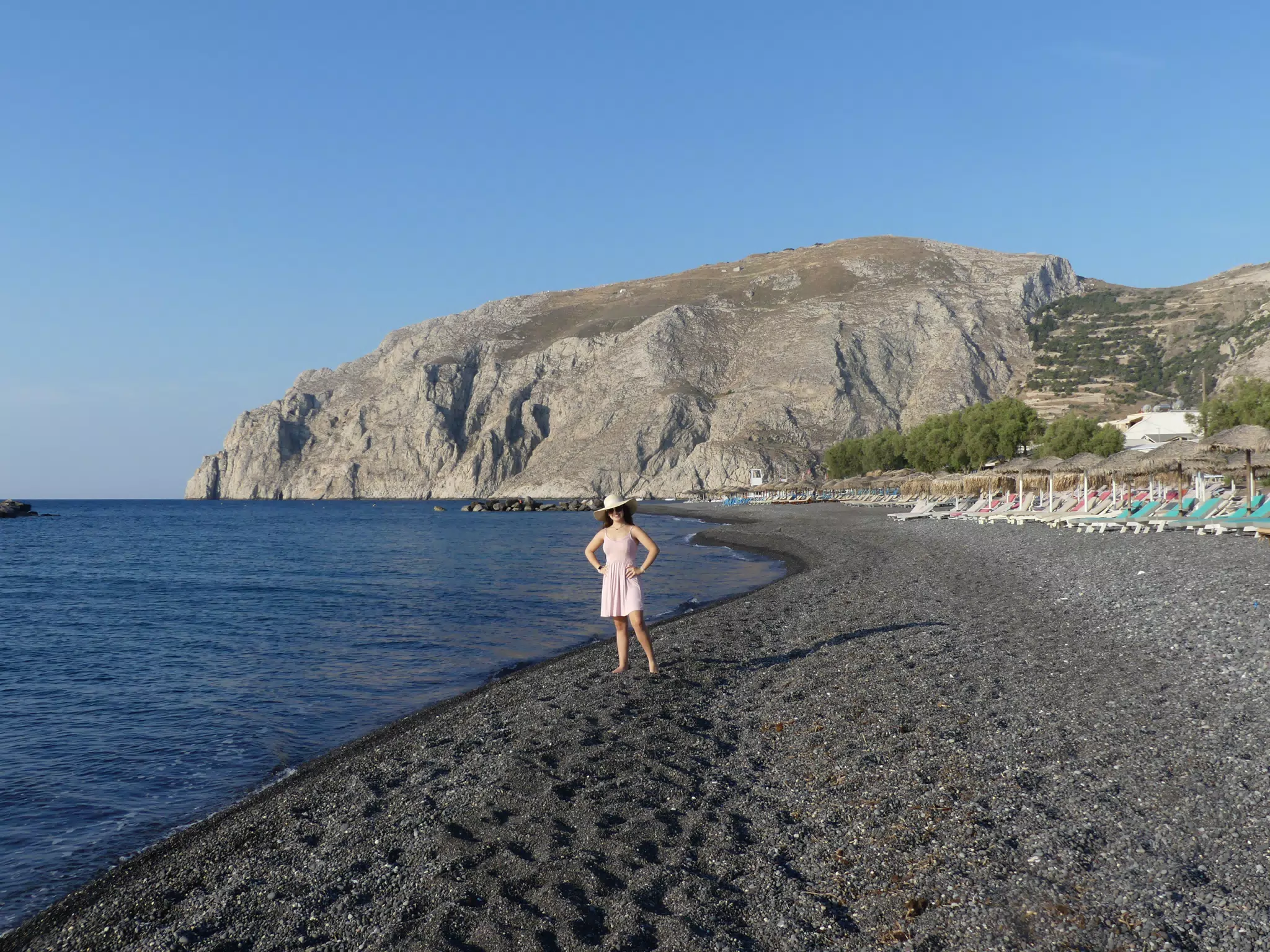 Girl on Aegean Sea Beach on Santorini in Front of Ancient Kamari