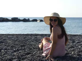 Teen in Hat and Sunglasses Looking Back on Kamari Beach