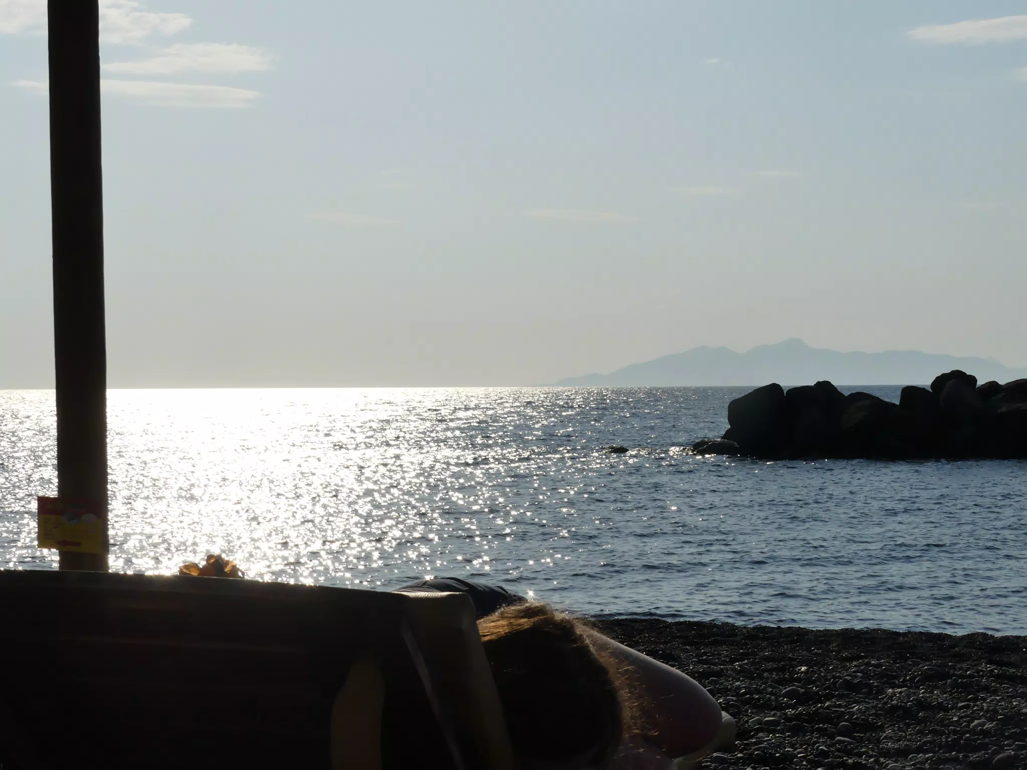 Sunrise over Kamari Beach with Girl Reading
