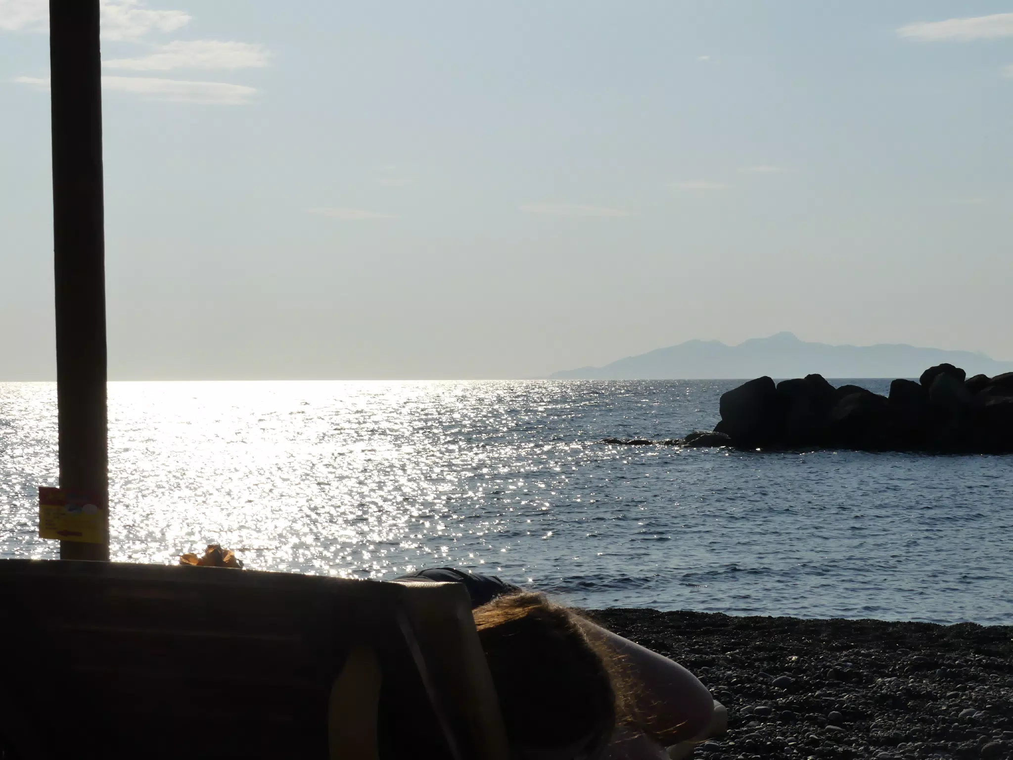 Sunrise over Kamari Beach with Girl Reading