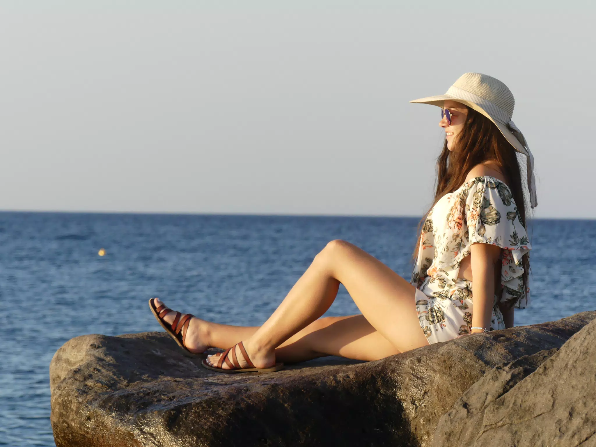 Emily Watching Sunrise at Kamari Beach on Rocks: Santorini, Greece