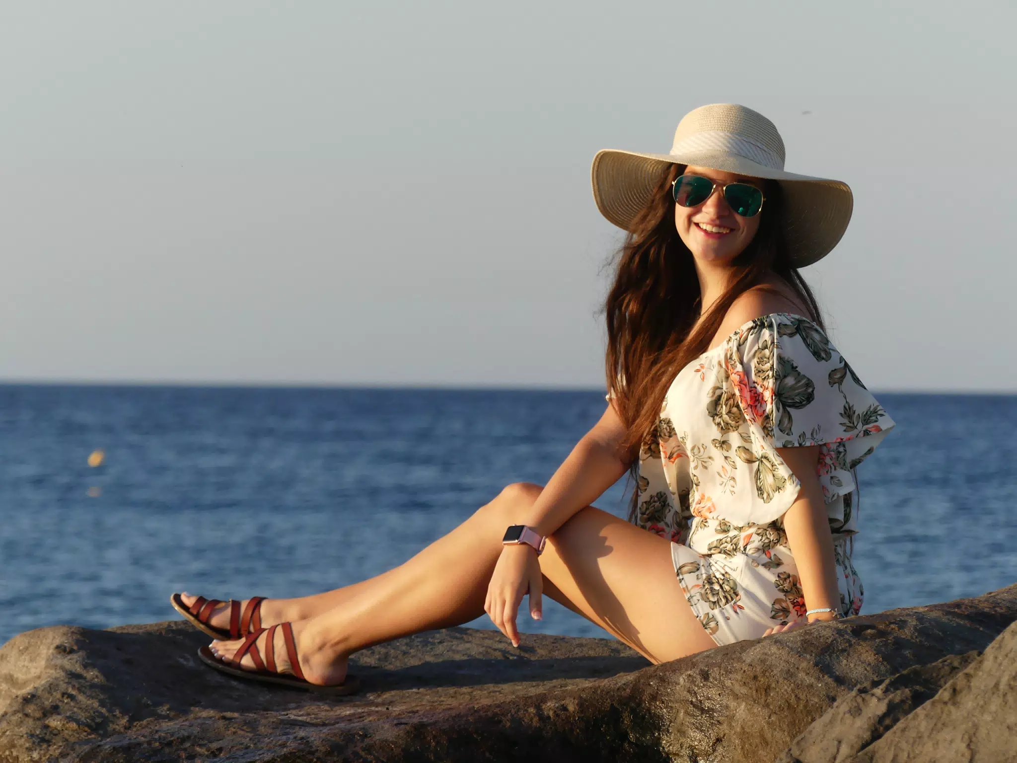 Girl on the Rocks on the Beach at Kamari, Santorini in the Sunrise
