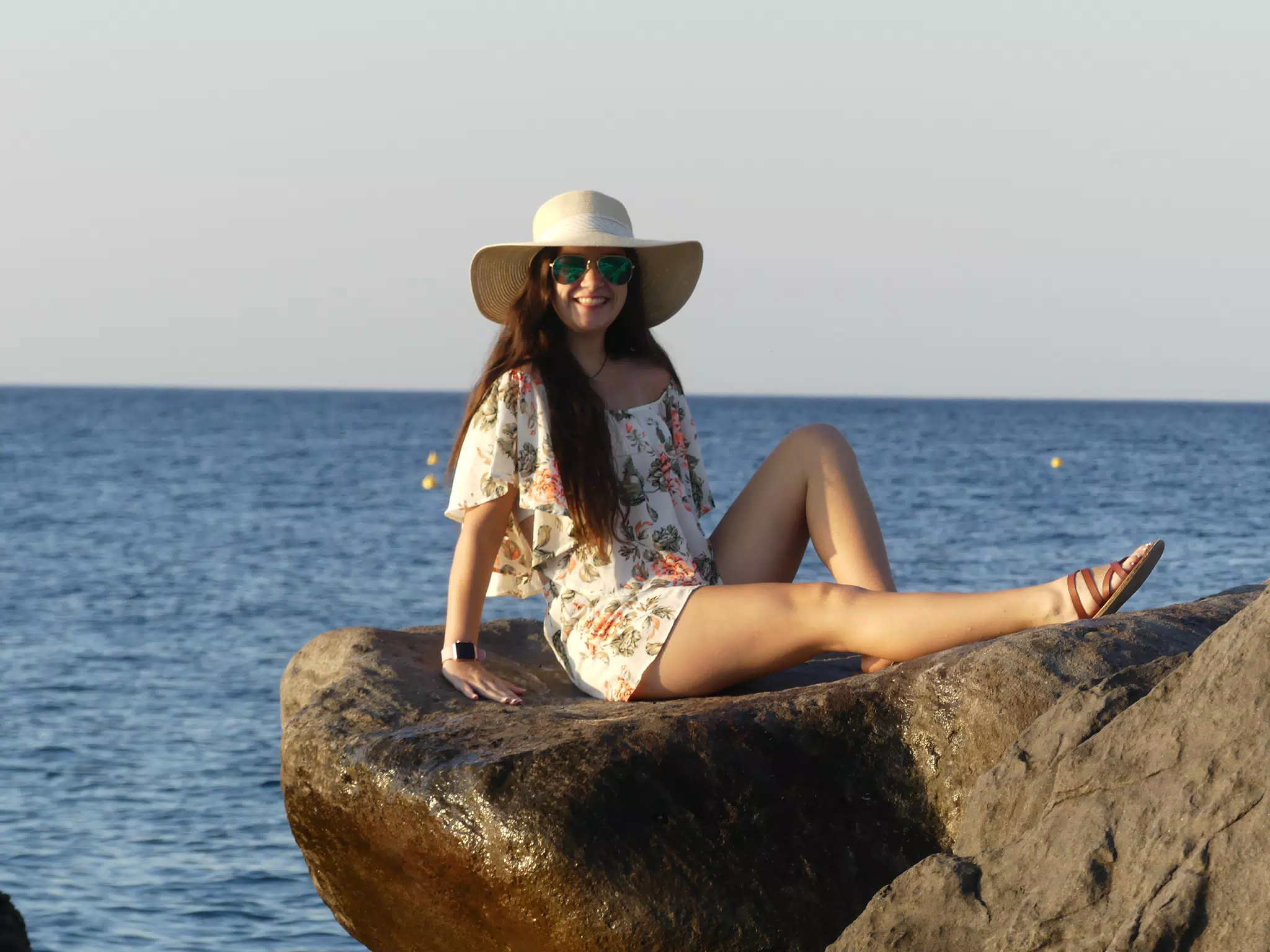 Girl on Santorini Sunning on the Rocks on the Beach at Sunrise