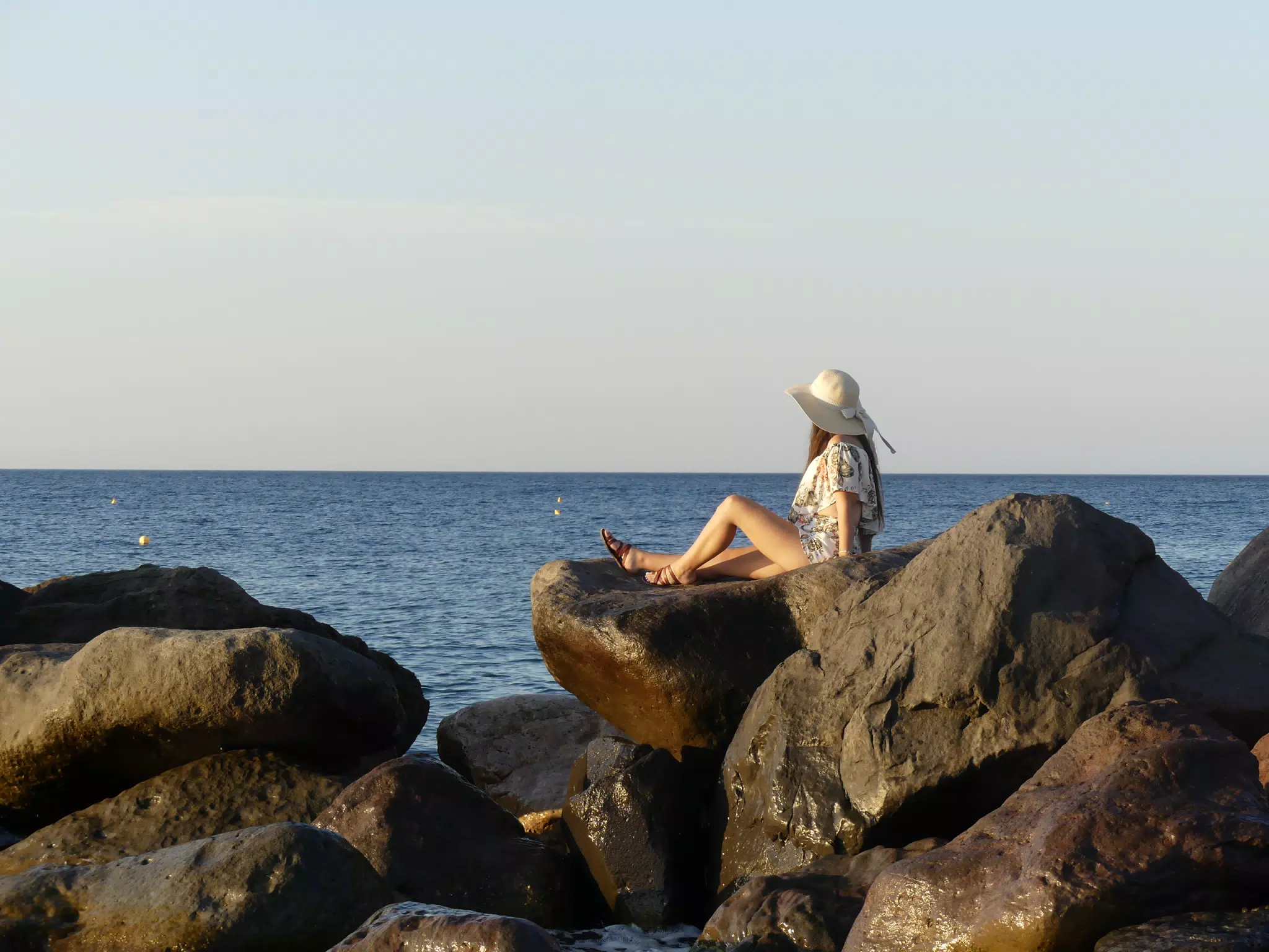 Girl on Rocks by Aegean Sea on Santorini