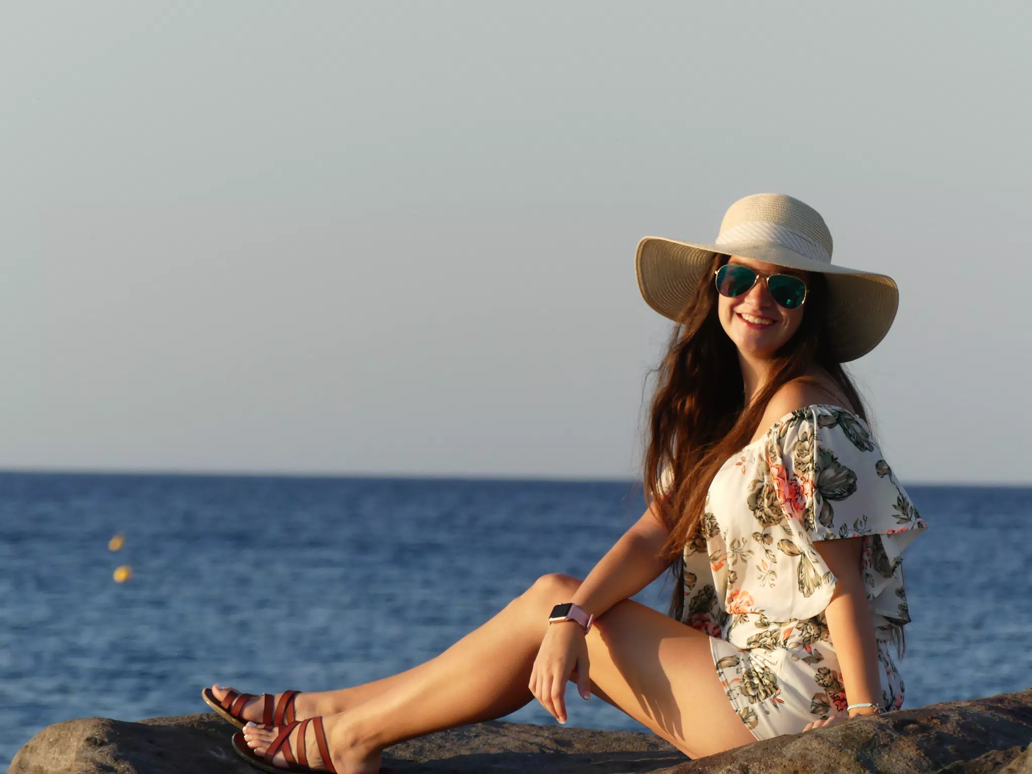 Girl in Hat on Rocks on the Beach on Santorini at Sunrise