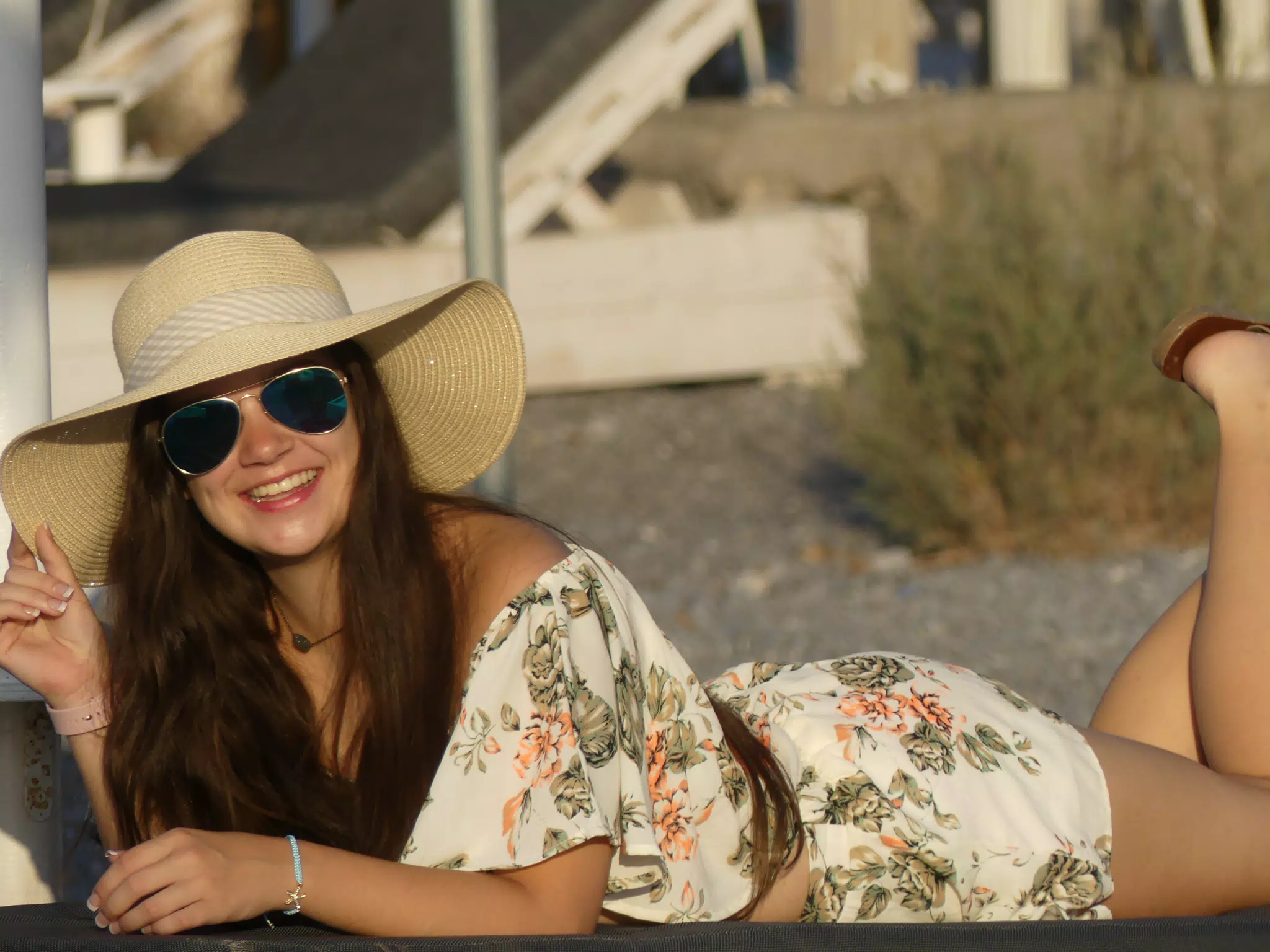 Girl in Hat Laying on Lounge Chair on Santorini Beach