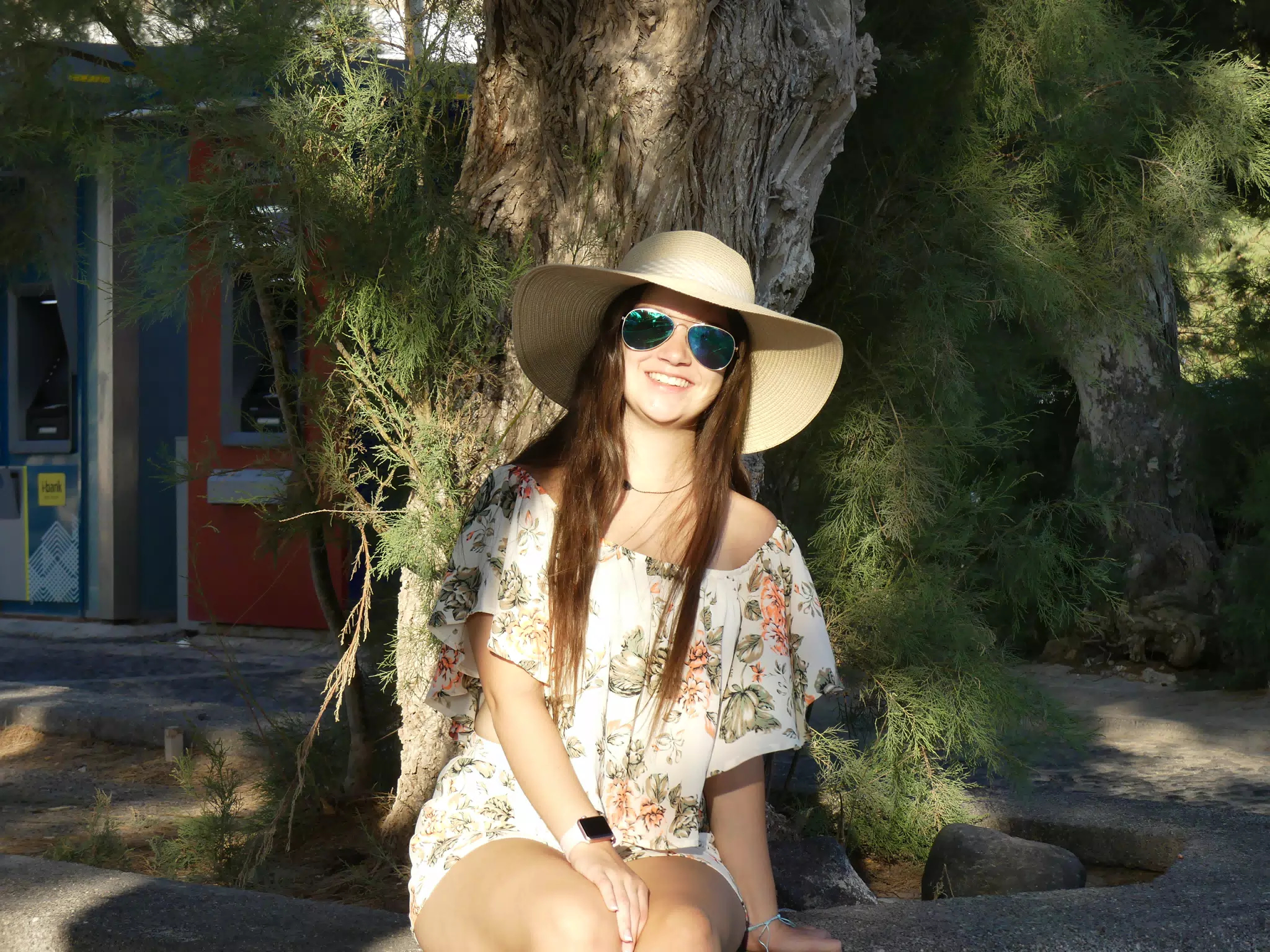 Girl Sitting on Curb Around Tree on Santorini