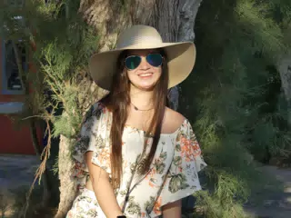 Emily in Hat in Front of Tree on Santorini