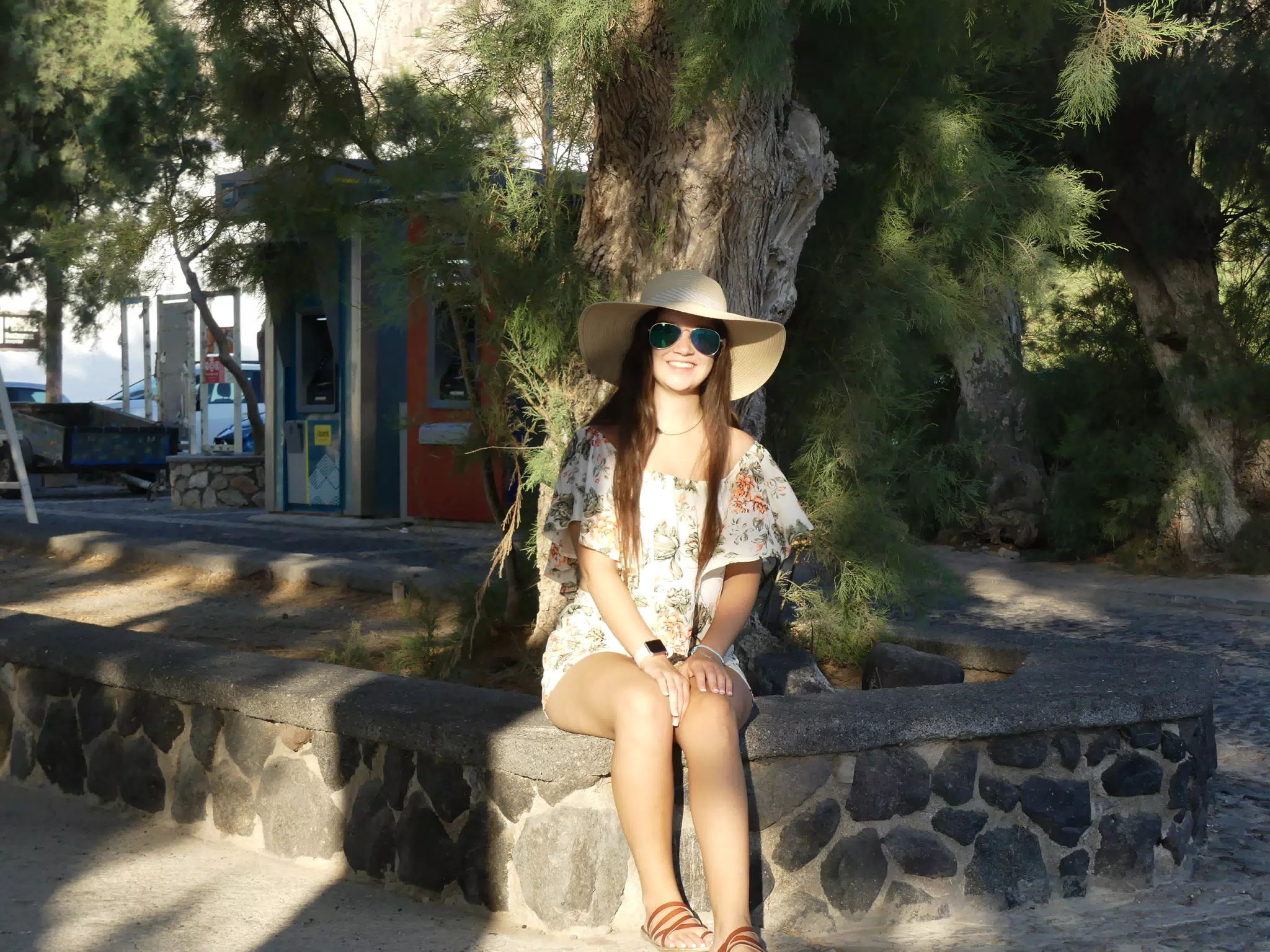 Emily Sitting in Front of Tree by Beach at Kamari on Santorini