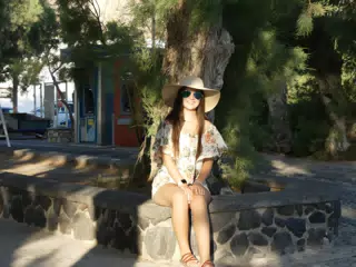 Emily Sitting in Front of Tree by Beach at Kamari on Santorini