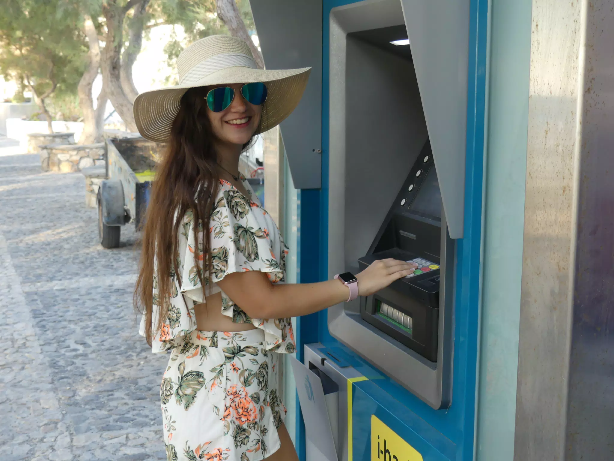 Teen Girl Using Cash Machine on Santorini