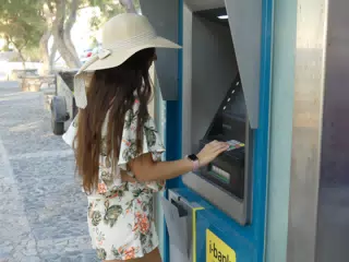 Teen Using ATM in Greece