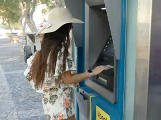 Teen Using ATM in Greece