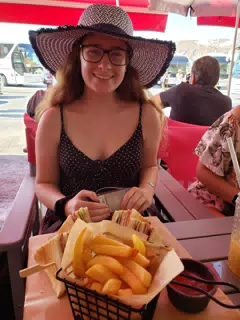 Madeline with Fries and Sandwich by the Sea on Santorini