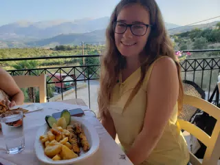 Madeline Eating at the Cretan Corner in Aptera